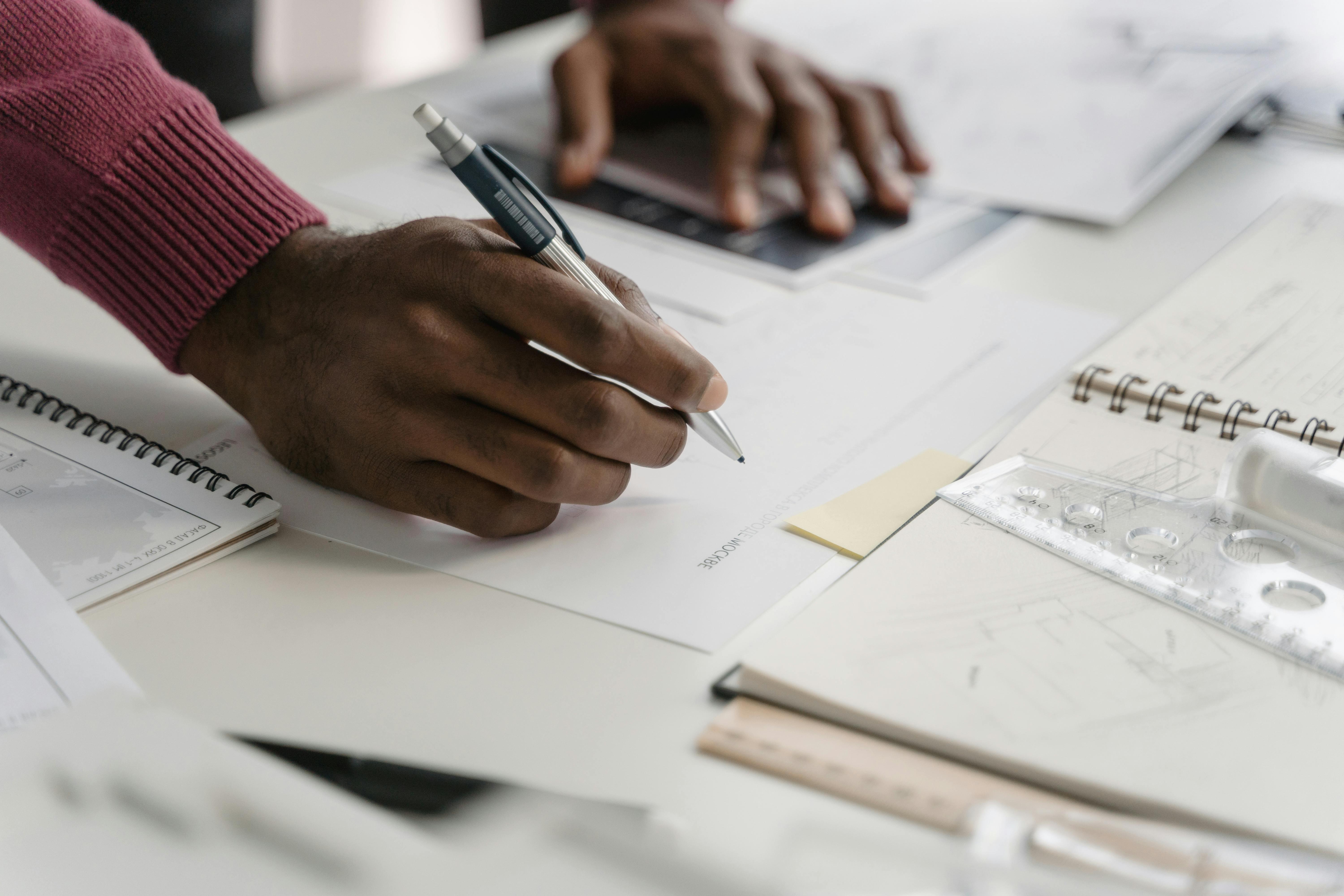 Gros plan sur des mains avec stylo sur des feuilles de travail
